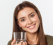 Does reverse osmosis remove fluoride? A woman smiles and holds a clear glass of water